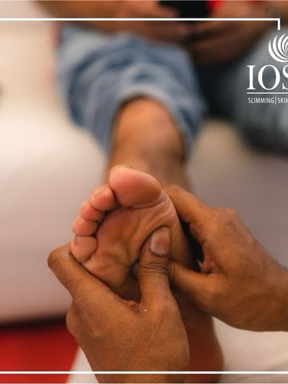A close-up of our foot reflexology in action. The therapist applies firm pressure with their thumbs to specific points on the sole of the foot, which correspond to different organs and systems in the body.
