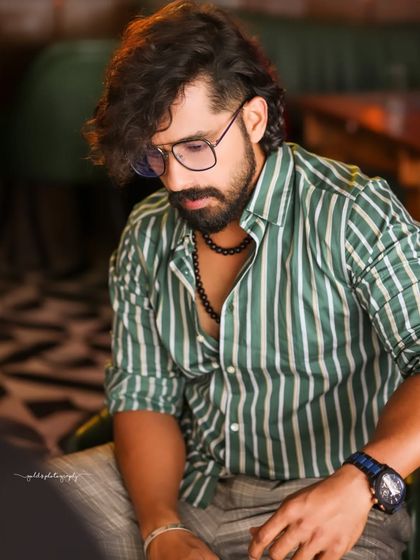 A collection of indoor portraits of an actor in a stylishly casual striped shirt. The moody lighting of the cafe setting adds a cinematic and modern feel, perfect for a character portfolio.