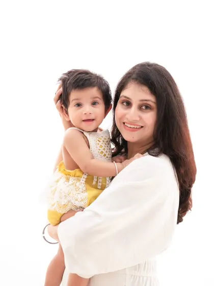 A beautiful mother and daughter moment. The simplicity of their matching white outfits against a clean background creates a timeless and pure image.