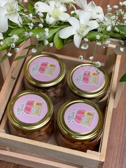 A beautiful wooden crate hamper for Rakhi, filled with jars of my savoury snacks and trail mixes, and decorated with fresh baby's breath flowers.