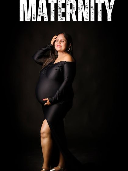 A smiling mom-to-be poses confidently in a black gown against a dark studio background. This classic setup creates a sophisticated portrait that focuses on her joyful expression.