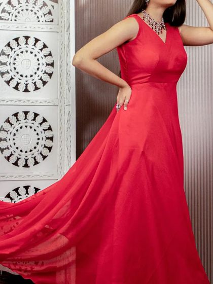 A side view of the flowing red gown, highlighting its beautiful drape and simplicity.