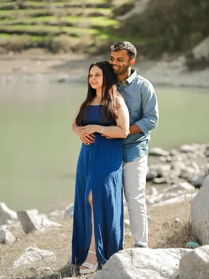A serene shot of a couple by the water in Dalhousie, enjoying the calm and beautiful scenery.