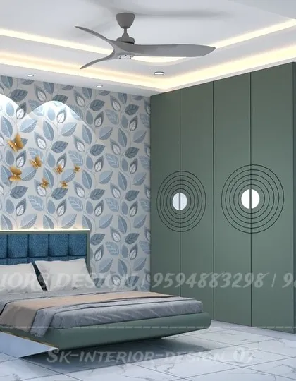 A vibrant bedroom design with sage green wardrobes featuring unique circular grooves. The floral wallpaper behind the bed adds a touch of nature and personality.