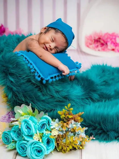 Capturing the sweetest dreams. This newborn is smiling peacefully, nestled in a cozy teal blanket. I use soft lighting and comfortable props to ensure your baby is safe and content throughout the session.