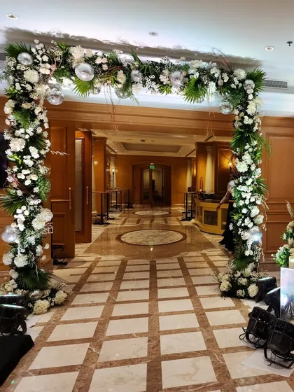 A lush entrance arch for a Sangeet, combining fresh white flowers and green foliage with sparkling disco balls. It’s a festive and glamorous welcome for a night of celebration.