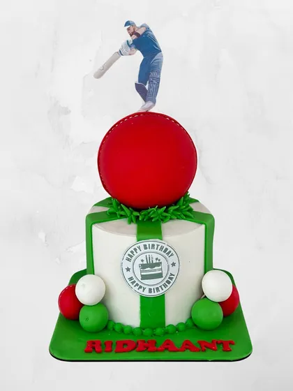 Howzat! A fantastic cricket-themed cake for Ridhaant, complete with a big red cricket ball and a batsman topper ready to hit a six.