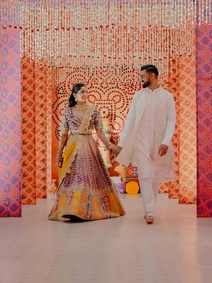 An entrance should be the beginning of the magic. For this Garba night, we designed a captivating tunnel using traditional bandhani-inspired prints and cascading floral strings, creating a vibrant and immersive walkway for the couple and their guests.