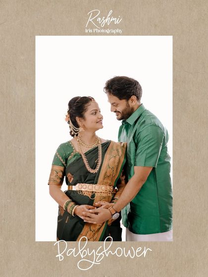 A classic portrait of a couple at their baby shower. Dressed in traditional green outfits, they stand together, with the husband's hands gently placed on his wife's baby bump.