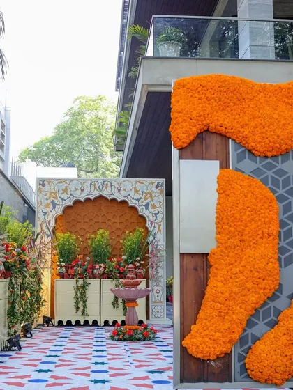 The entrance walkway, flanked by modern marigold installations on the walls. This blended a contemporary floral art style with the traditional theme of the event.