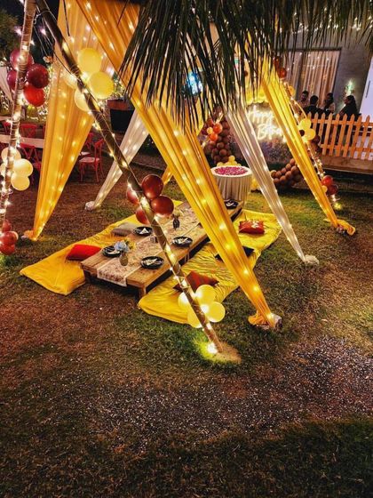 This view shows the low seating arrangement with a mix of yellow mats and red cushions. It's a comfortable and informal way for guests to gather and enjoy a special meal together.
