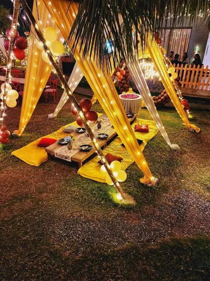 This view shows the low seating arrangement with a mix of yellow mats and red cushions. It's a comfortable and informal way for guests to gather and enjoy a special meal together.