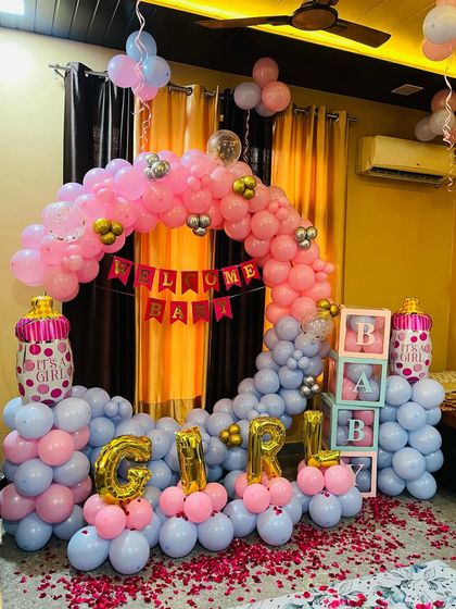 This is another view of a popular welcome home setup for a baby girl. It shows the full balloon arrangement with pink and grey balloons, "GIRL" letter foils, and baby-themed props, perfect for any home in Noida or Delhi.