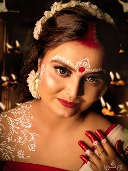 A traditional Bengali look for Durga Puja, featuring the classic white and red makeup (Chandan).
