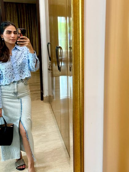 A chic look pairing a light blue eyelet shirt with a long denim skirt. This is a great way to style denim for a more dressed-up occasion.