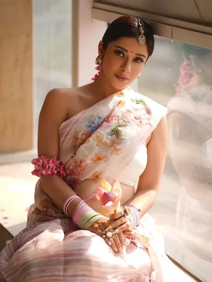 A beautiful window-lit portrait of Nyra Banerjee. The soft, diffused light enhances the delicate floral print of the saree and gives her skin a radiant glow.