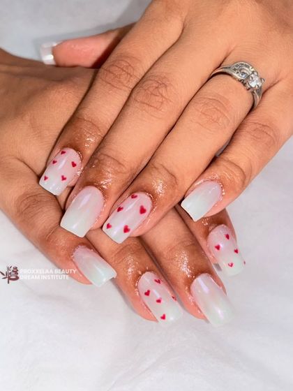 Falling in love one nail at a time. This sweet and stylish set features a pearly white base with tiny red hearts, perfect for a romantic vibe.