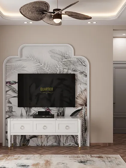 The TV unit in the Indochine master bedroom is set against a matching wallpaper panel, creating a cohesive look. The floor-mounted console is simple and elegant, keeping the focus on the beautiful wall treatments.