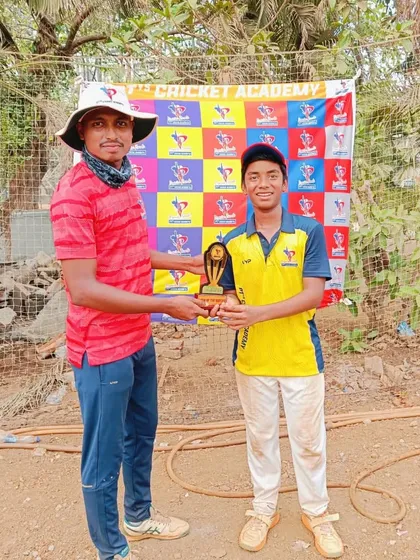 A coach in a distinctive bucket hat presents a Man of the Match award to a deserving U-14 player.
