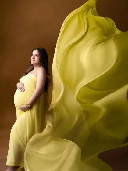 A burst of sunshine. The vibrant yellow gown with its flowing train brings energy and joy to this beautiful maternity portrait.