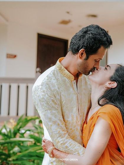 A sweet kiss shared by Eli and Suman after their Haldi ceremony. The love and happiness are palpable in this candid moment.