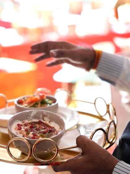 A golden tray presenting a selection of our finest Indian appetizers, including Dahi Bhalla topped with pomegranate seeds.