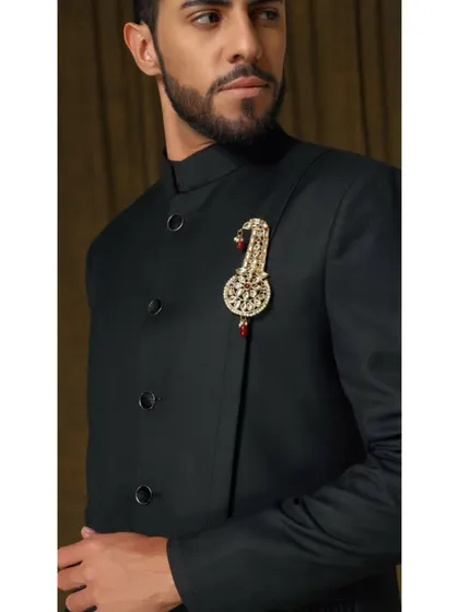 The Vishudh bandhgala in a sophisticated black silhouette. The design is elevated by a jeweled kalgi-style brooch, adding a touch of royalty to the minimalist design.