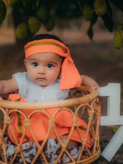 A serious moment from our little mango pie. The rustic basket and half-birthday sign complete this adorable outdoor setup.