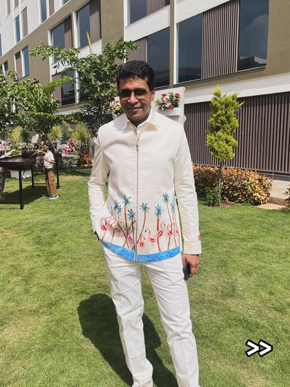 A full-length view of a client wearing a custom jacket with a beachy, tropical vibe. I painted palm trees and flamingos to create a relaxed yet stylish look perfect for a destination wedding or carnival event.