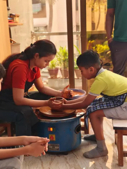 An instructor provides gentle, hands-on guidance to a young student at the pottery wheel. We believe art is for everyone, and our studio is a nurturing space for artists of all ages to learn and grow with confidence.