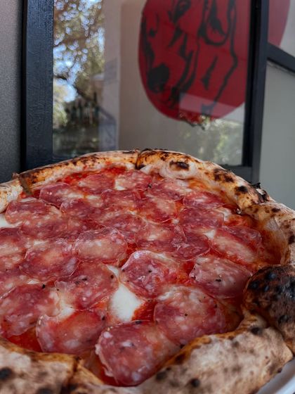 A close-up of our salami pizza. We use high-quality cured meat that gets wonderfully crisp in our wood-fired oven.