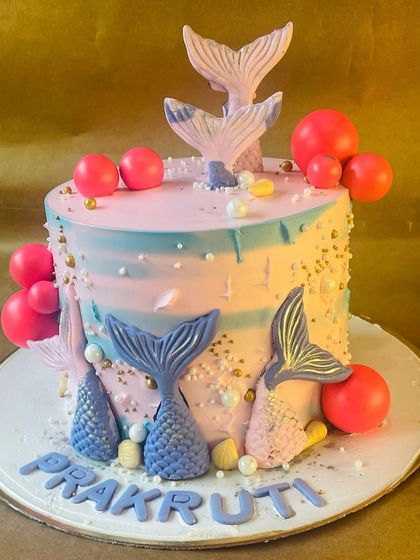 A side view of the enchanting mermaid cake, showing the textured frosting and scattered gold details that mimic the magic of the sea.