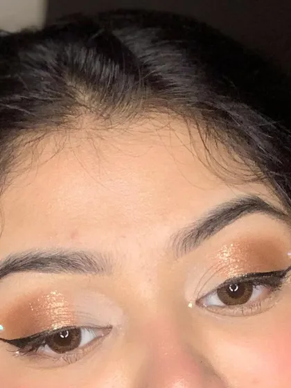 A close-up of a soft glam eye look with a sharp wing and delicate pearl accents.