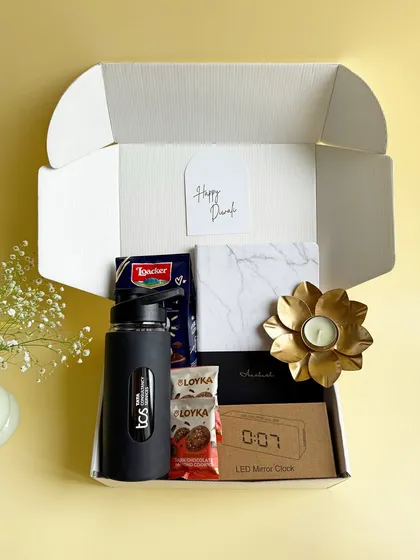 Unboxing a thoughtful Diwali gift. This hamper includes a TCS branded bottle, a digital clock, a marble-finish notebook, and gourmet treats, making it a practical and delightful present for any professional.