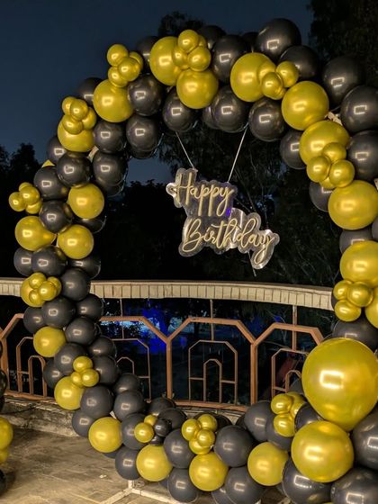 A close-up of the black and gold circular balloon arch, perfect for outdoor evening parties.