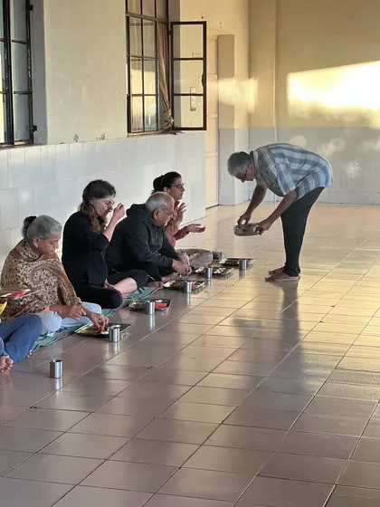 The practice of Karma Yoga, or selfless service. Here, I am serving food to participants during a community meal, an act of love and humility that is central to the yogic path.