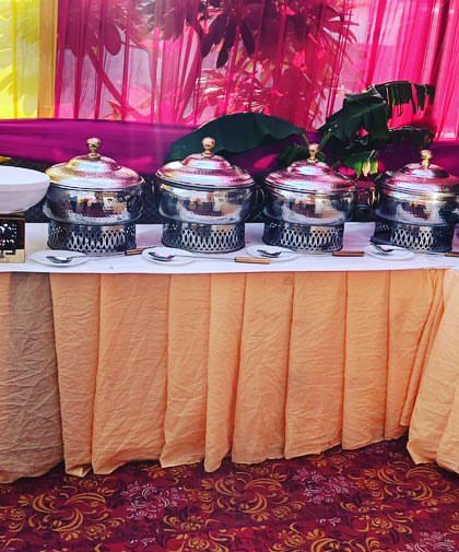 A colorful buffet arrangement for a private catering event of 90 guests in Sangam Vihar. The vibrant linens and decor add a festive touch to the celebration.