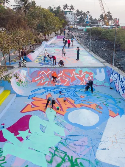 An early stage of the collaboration, with multiple artists laying down the base layers and outlines across the skatepark's ramps and flats.