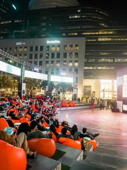 Welcome to your perfect movie night. Imagine sinking into a comfy bean bag in the heart of the city, with a massive screen, immersive headphones, and nothing but the story in front of you. This is our signature open-air cinema experience at DLF CyberHub.