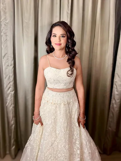 The final sangeet look with side-swept voluminous curls. This hairstyle is perfect for dancing the night away, as it keeps the hair controlled while still looking glamorous and full.