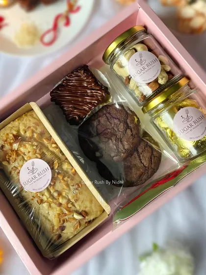 The 'Pyaar Bhaara' Rakhi hamper, beautifully arranged with a tea cake, brownie, cookies, and jars of nuts and chocolates.