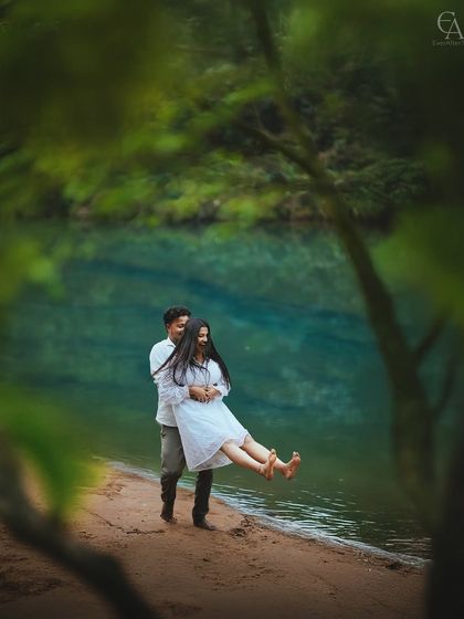 A playful lift at the edge of a crystal-clear lake. The natural framing from the leaves adds an intimate, secret-garden feel to this fun and candid couple portrait.