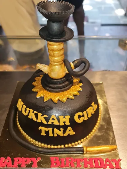 A unique and bold hookah-themed cake for an adult birthday. This sculpted cake features a detailed hookah pipe in black and gold, making for a memorable and personalized centerpiece.