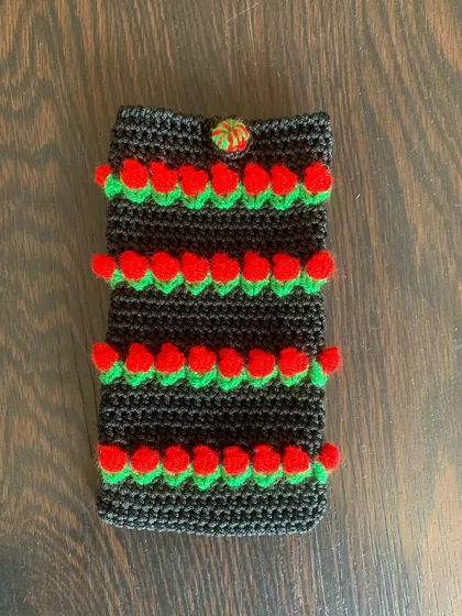 For a bolder look, this mobile pouch features bright red tulips against a black background, creating a striking contrast.