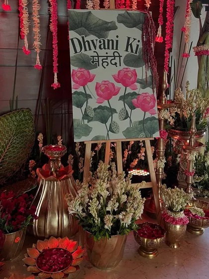 A closer look at the personalized mehendi welcome sign, surrounded by fresh tuberoses and brass lamps.