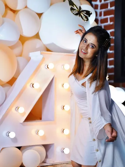 Me, posing with the marquee '4' light at a birthday party. We can create custom marquee signs with any number or letter.