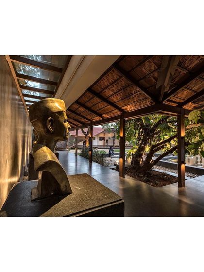 A bust of one of the institution's founders is framed by the new "Rishi Pavilion." The architecture serves to honor the history of the place while creating new experiences.