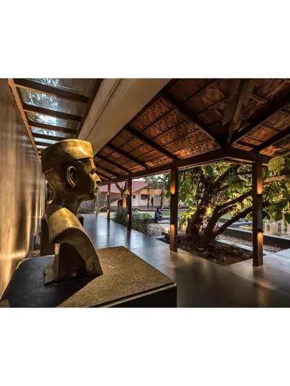 A bust of one of the institution's founders is framed by the new "Rishi Pavilion." The architecture serves to honor the history of the place while creating new experiences.