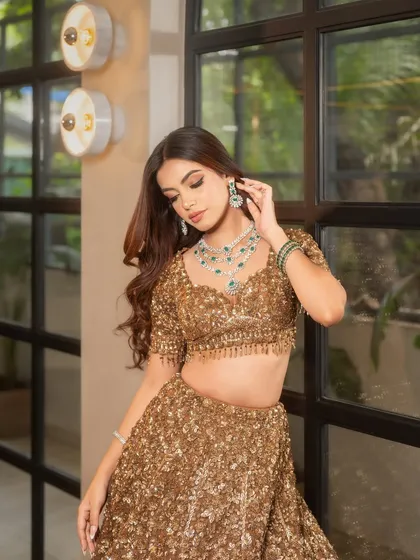A soft, romantic pose highlights the beautiful flow of the waves and how they frame the face and complement the stunning diamond and emerald jewelry.