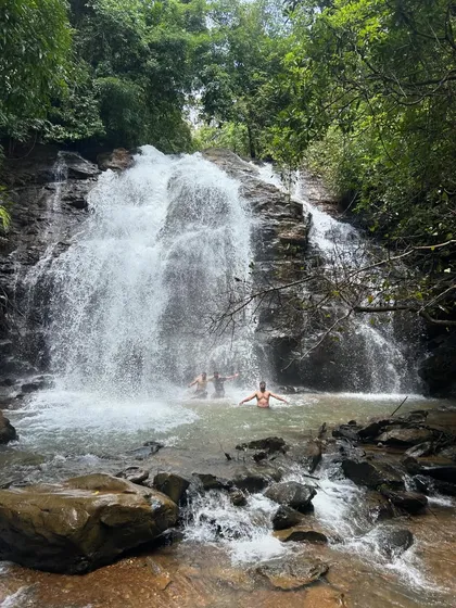 A couple enjoying the refreshing waters at the base of a beautiful waterfall in Uttara Kannada.